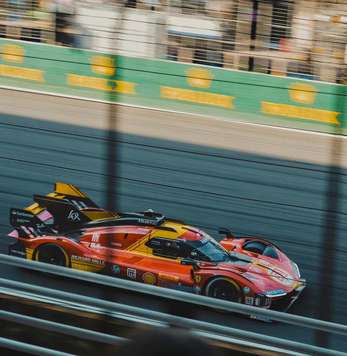 Red and yellow racing car against a motion-blurred track background.