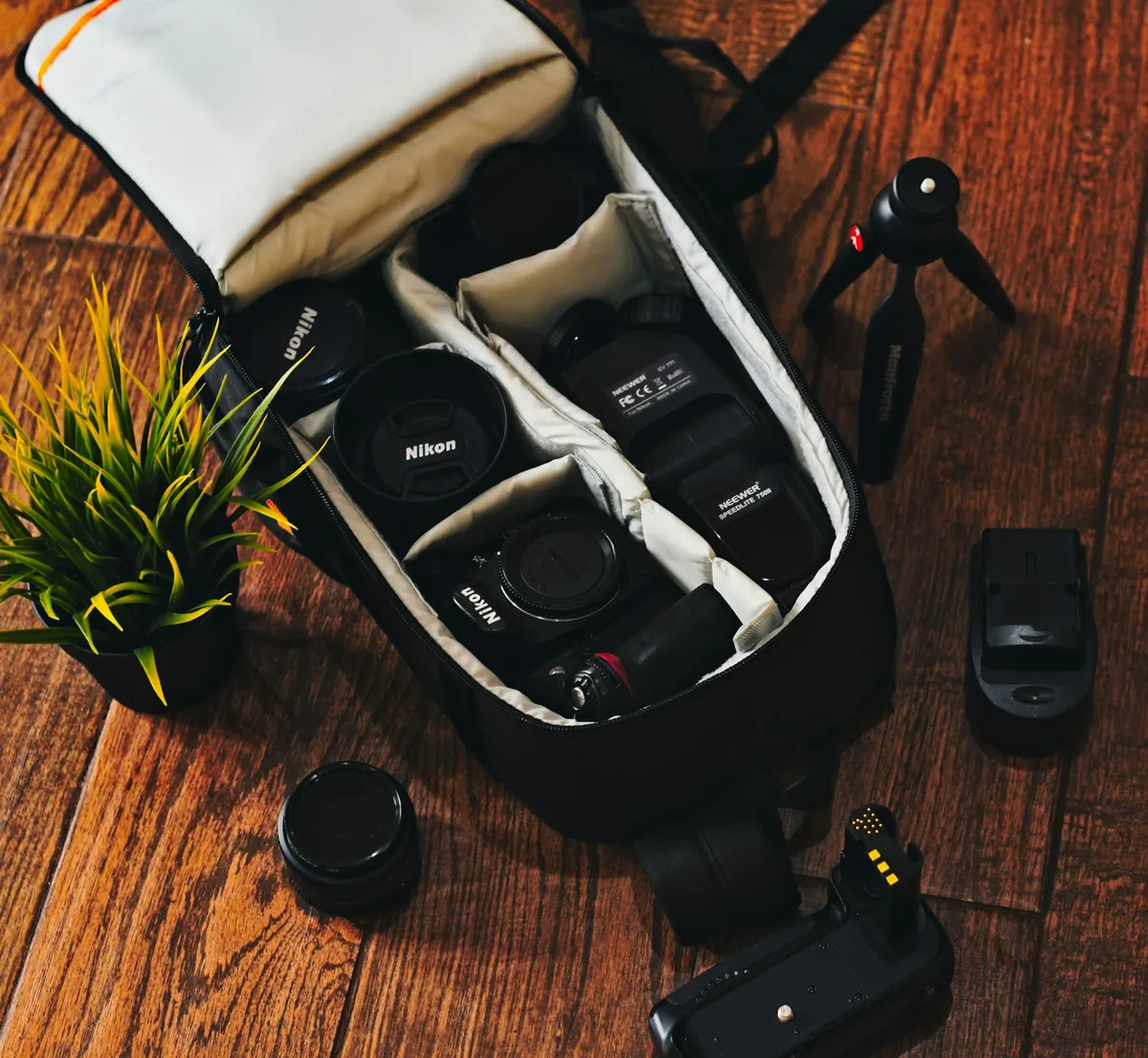 Cameras, lenses and a flash arranged inside an open padded camera bag.