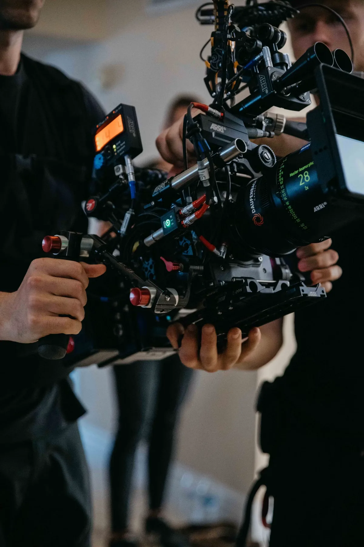 Crew holding an ARRI cinema rig with a Master Anamorphic 28mm lens and focus-control equipment