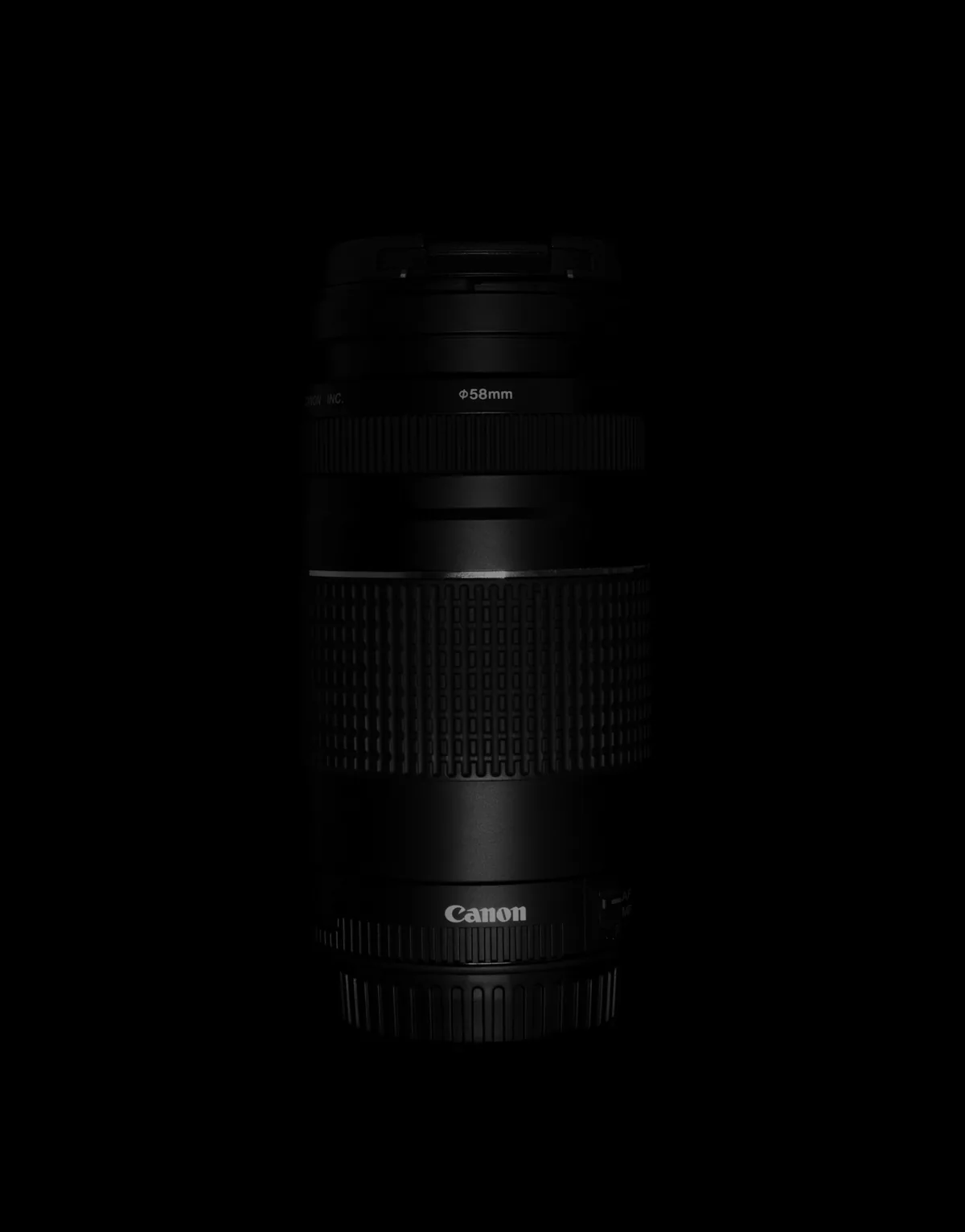 Canon zoom lens standing upright against a black background, with a 58mm cap on top.