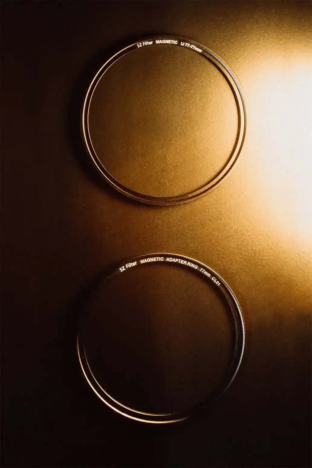 Two SZ Filter magnetic adapter rings photographed on a gold-colored surface.