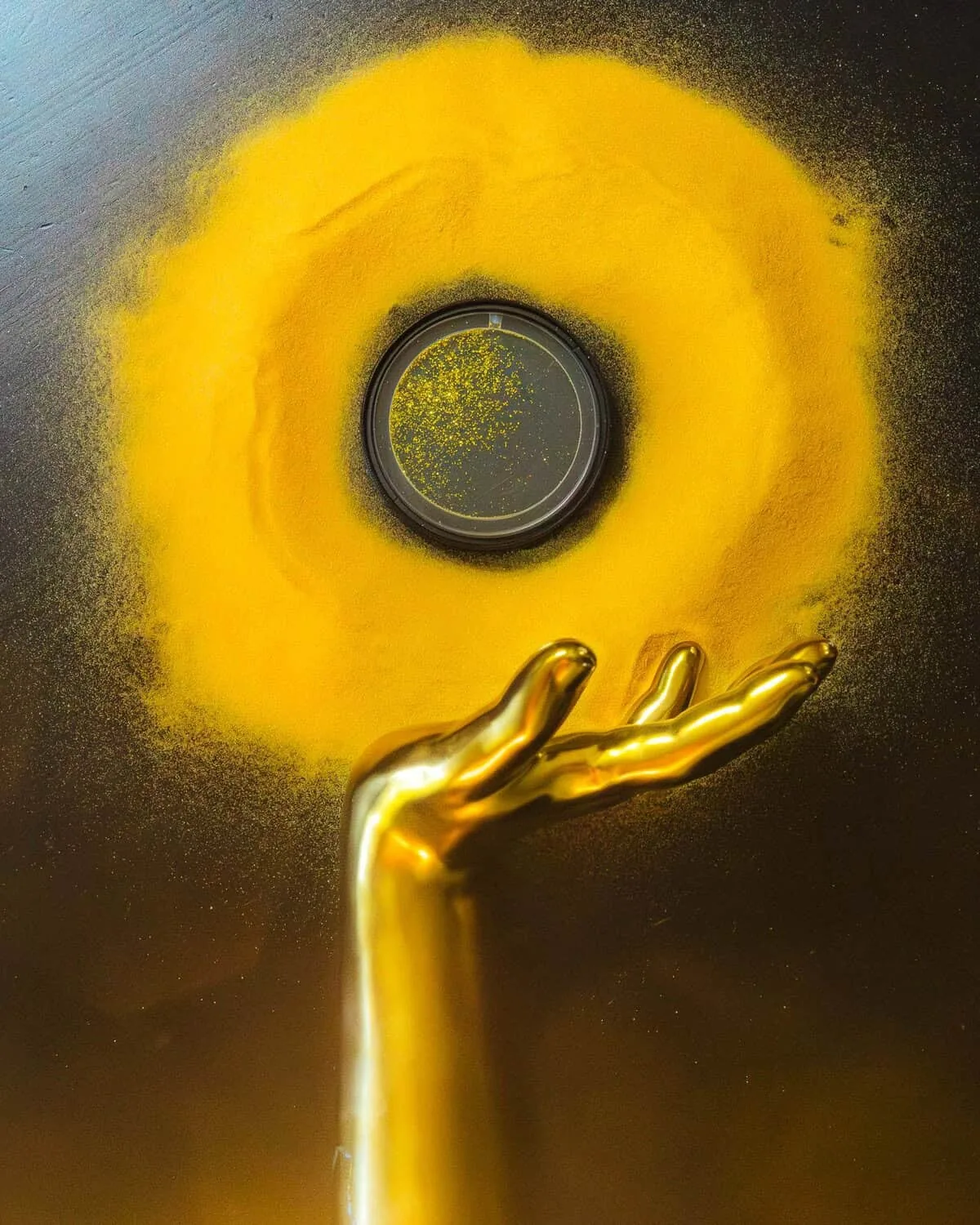 Circular Midas Touch filter beside gold-colored decorative objects on a dark surface.