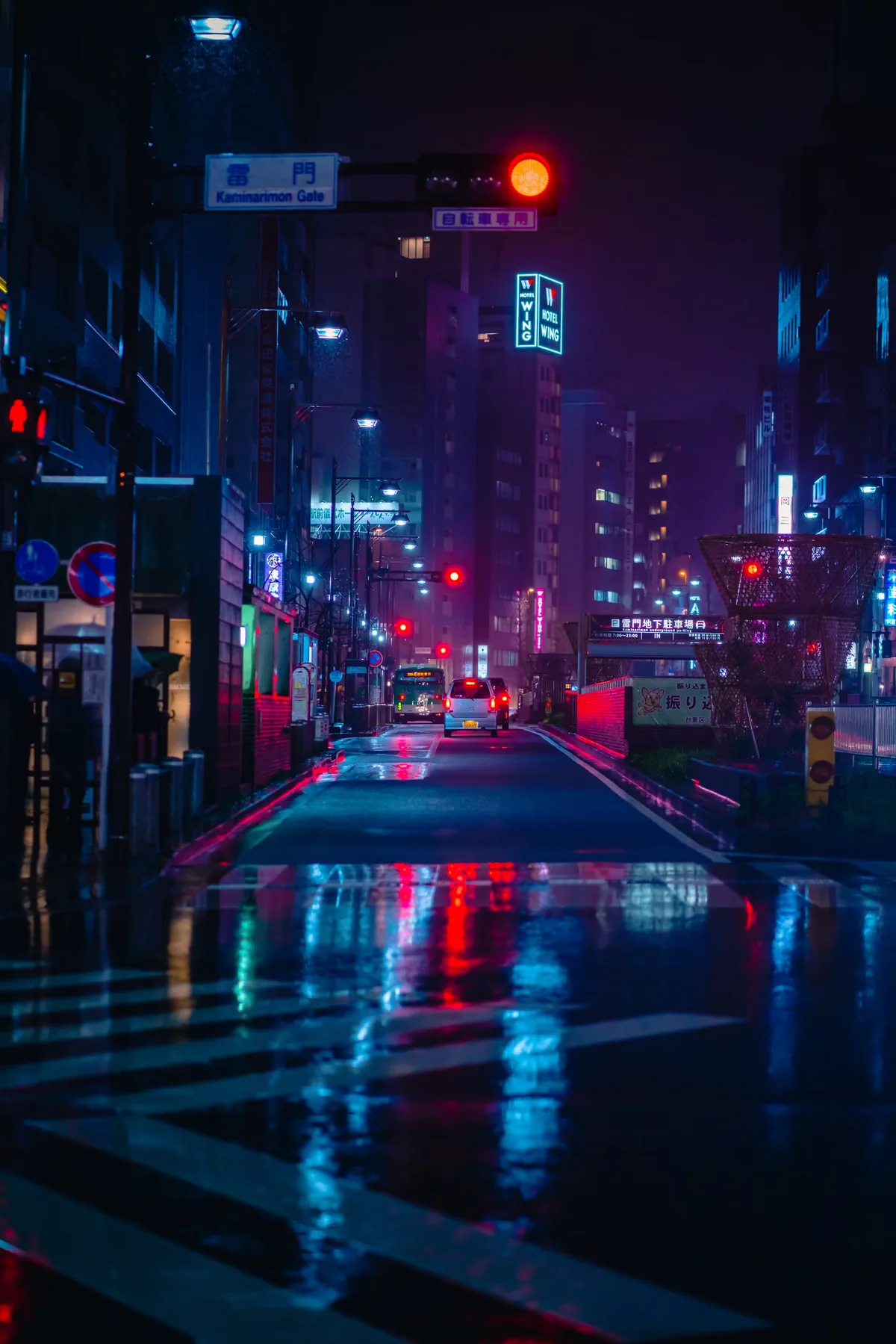 Rain-soaked street glowing with neon lights at night