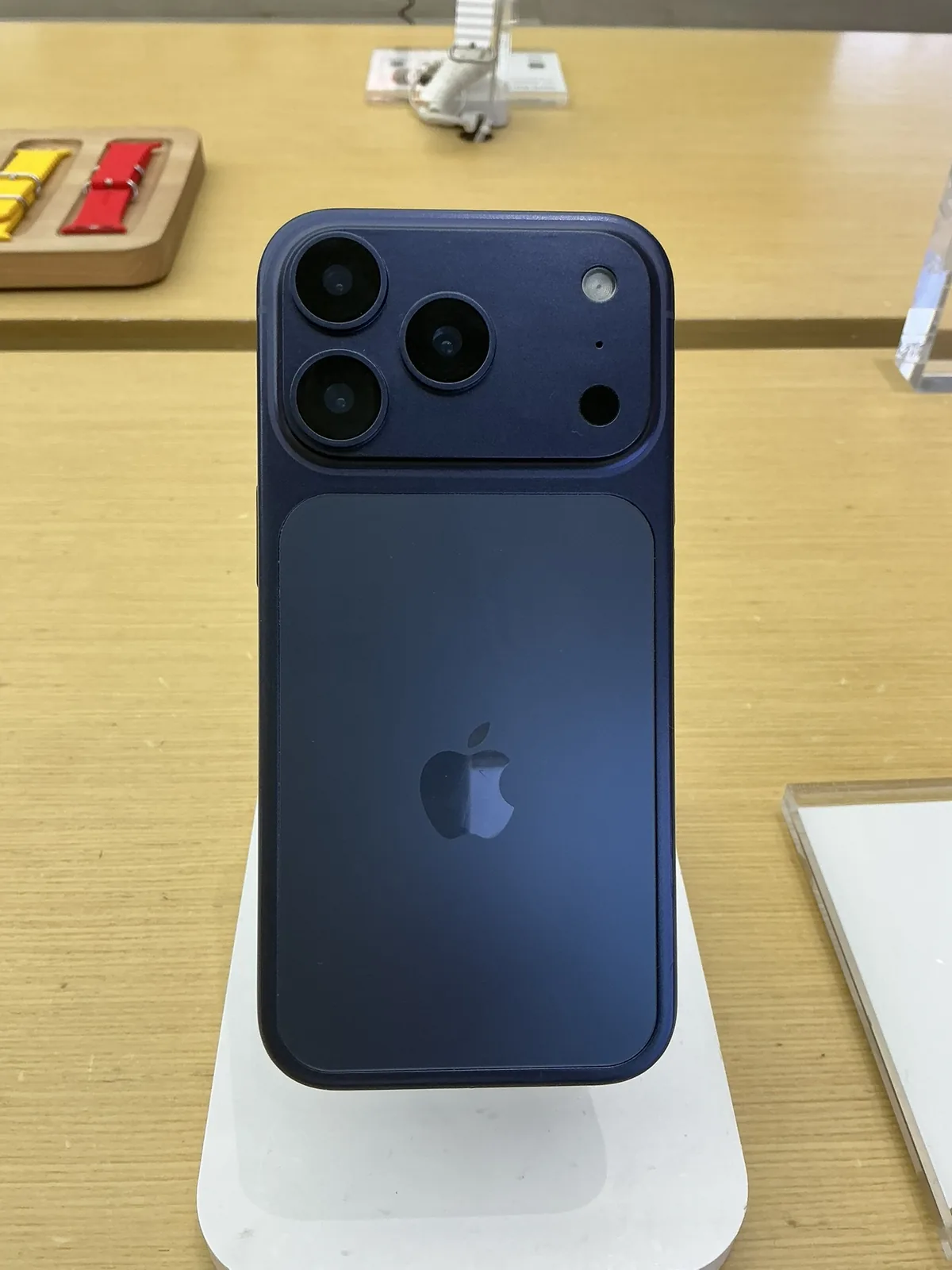 Blue iPhone 17 Pro standing on a security display in a store.