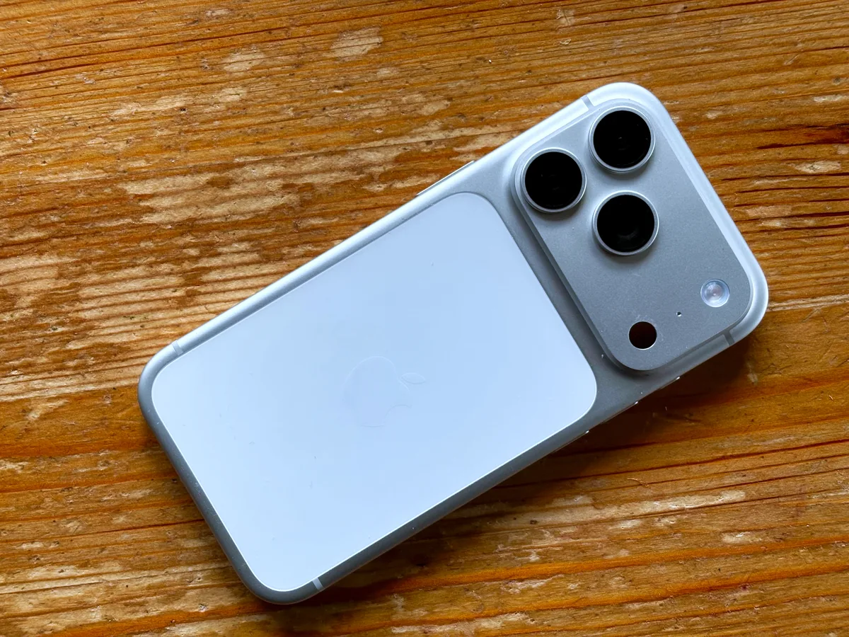 Silver iPhone 17 Pro lying diagonally on a wooden surface.