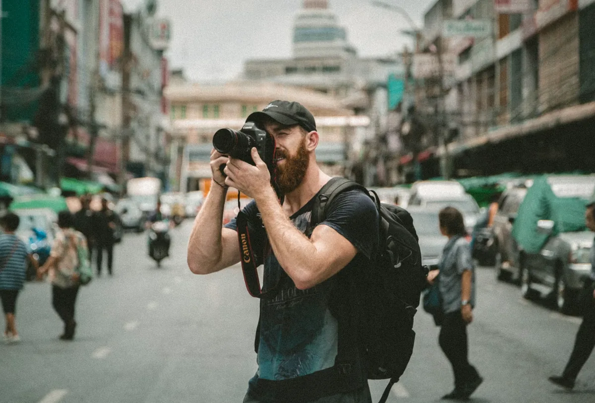 Street photographer raising a camera in a city