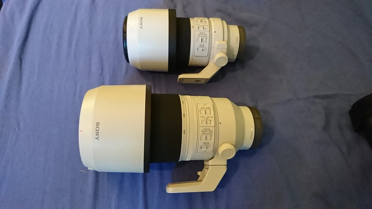 Contextual Sony FE 70–200mm F4 G and FE 100–400mm GM zoom lenses on blue fabric, not the newly announced primes