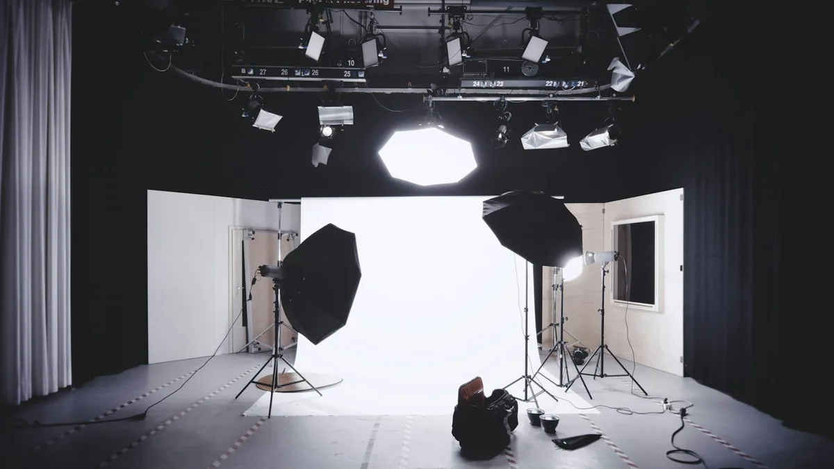 Photographic studio with a white sweep, softboxes, light stands and overhead fixtures.