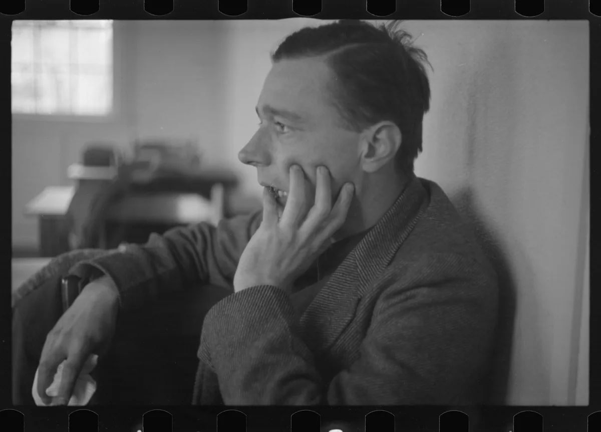 Walker Evans in profile with one hand raised to his face