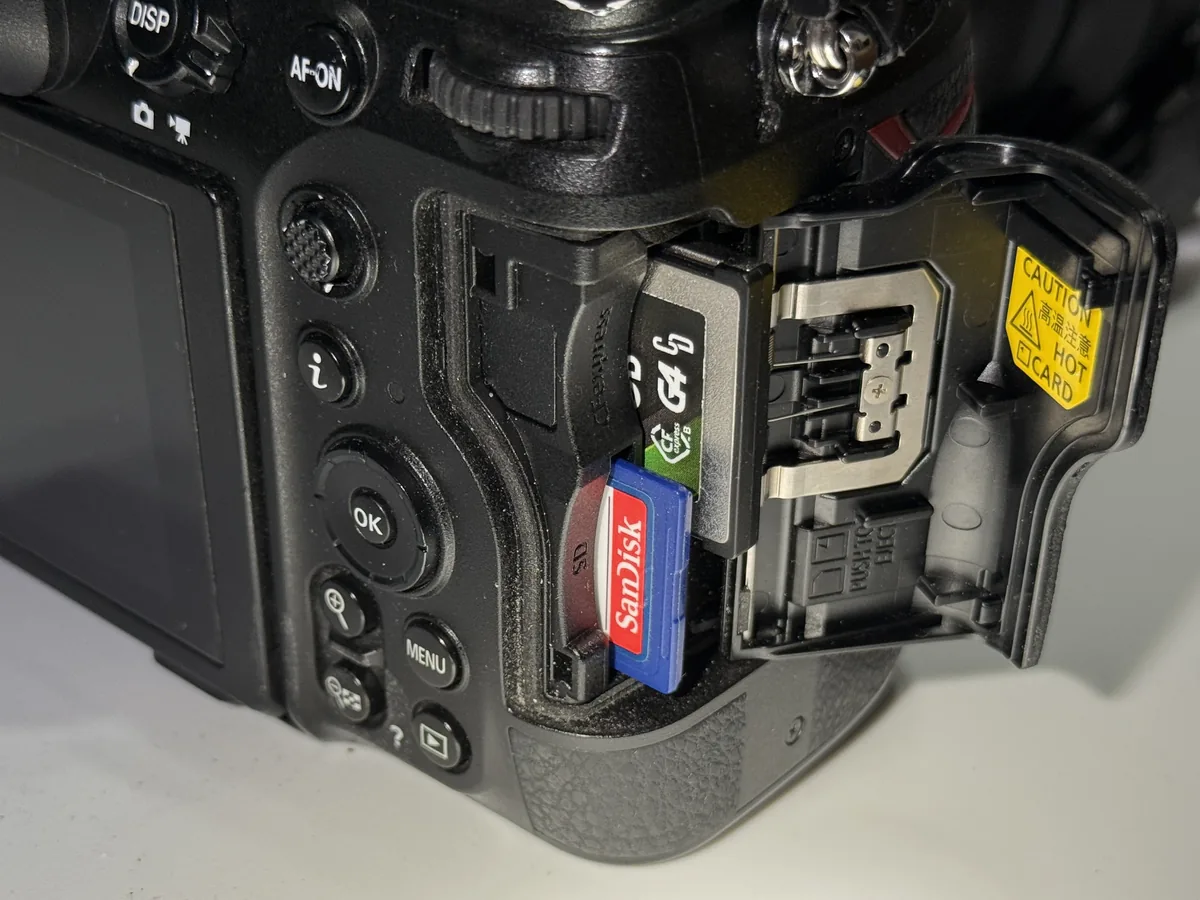 Nikon Z8 card compartment with CFexpress and SD cards and a hot-card caution label